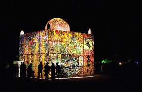 At night, the plastic chapel (rebuilt temple of burning book) glows through its intricate patterns of plastic art
