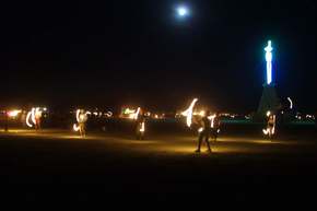 Before the burn, the fire dancers perform their ceremony.  The moon rises behind them.
