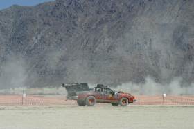 Heat rises from desert behind custom car
