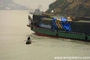 Locals on the river ride the wake of a big cargo ship carrying trucks.  It's a bumpy experience.
