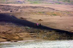 Family walks over the trail of coal left by moving it to barges
