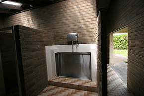 Typical Australian middle grade urinals are shared, stainless steel affairs, often with just a grate in front.