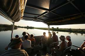 Tourists look into the sunrise on the tourboat