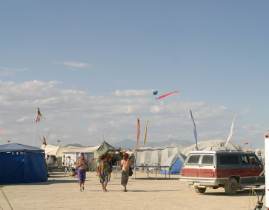 Skydivers land on the playa, viewed inside OCF camp