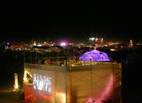 Center camp with the former refinery in front of it, projecting movies