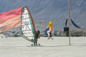 Two wind-surfers cross in opposite directions before Thunderdome