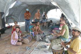 People play music in the entrance to Embassy camp