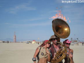 David Silverman with his flaming tuba, poses with two ladies who can't resist him