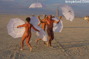 Ed Joseph and his two new acolytes dance at sunset with white umbrellas
