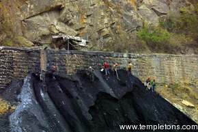 Coal is just dumped on the side of the gorge.  Men work it at a perilous angle.  All this coal will be flooded.