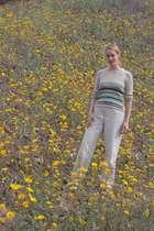 K. stands on flower-carpeted hillside
