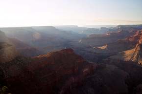 Streams of light beam into the canyon as the sun sets through the (all to common) haze.