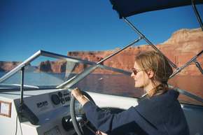 One of a couple of shots of Kathryn at the wheel, going about 35MPH in our boat.   Some lovely (if slightly blurry) red canyon walls at our right.